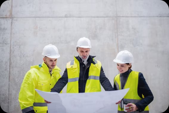 NYC building compliance inspectors reviewing blueprints on a construction site
